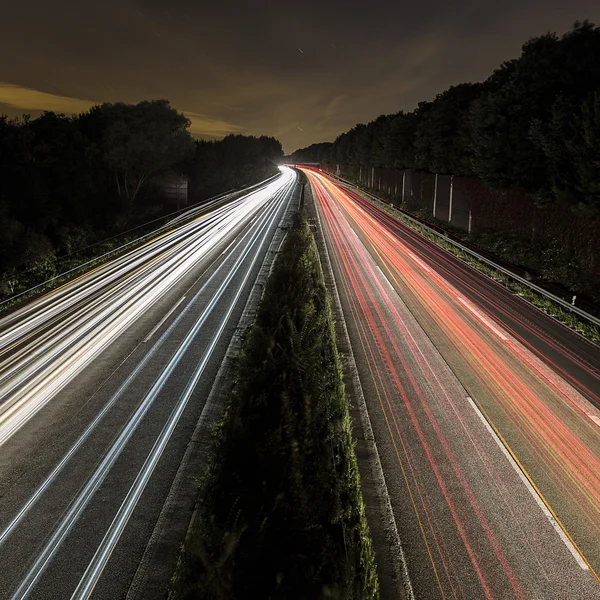 Long time exposure freeway moon cruising car light trails streaks of light speed highway — Stock Photo, Image