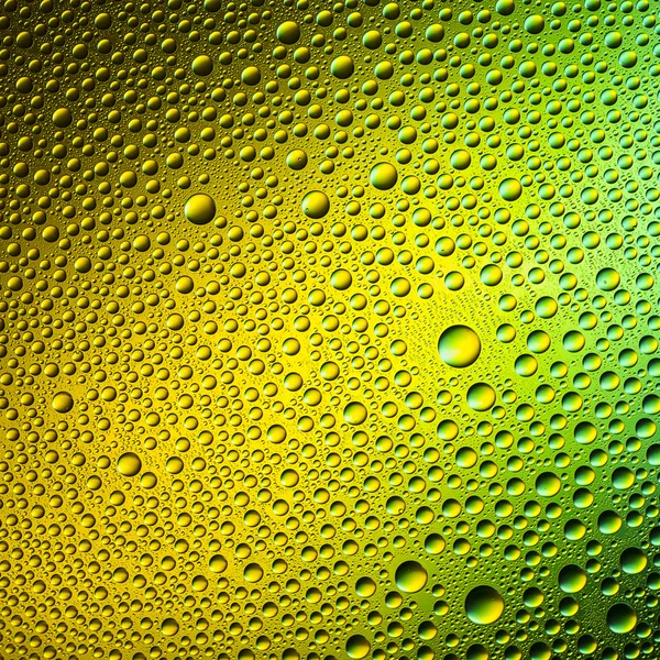 Gocce d'acqua spettrale verde giallo oro colori gradiente arcobaleno colorato perline lotuseffekt tau tenuta — Foto Stock