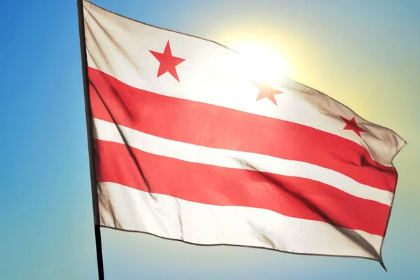 Washington DC of United States flag waving on the wind in front of sun