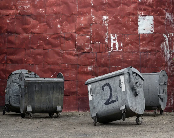 Kırmızı metal duvar ile çöp konteyneri — Stok fotoğraf