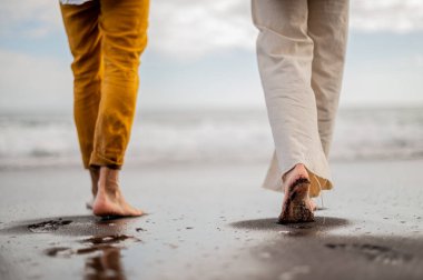 Kumsalda yürürken birkaç adım. Yüksek kalite fotoğraf. Bulutlu hava.