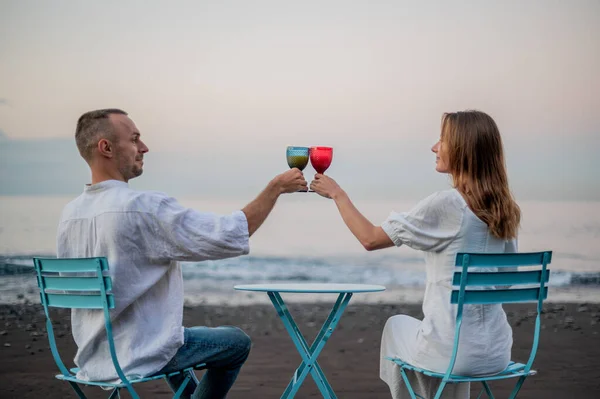 Young Couple Sitting Beach Sunset Drinking Wine Out Glass High — Stock Photo, Image