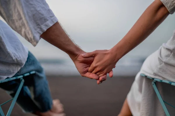 Young Couple Holding Hands Sitting Beach Sunset High Quality Photo — Stock Photo, Image
