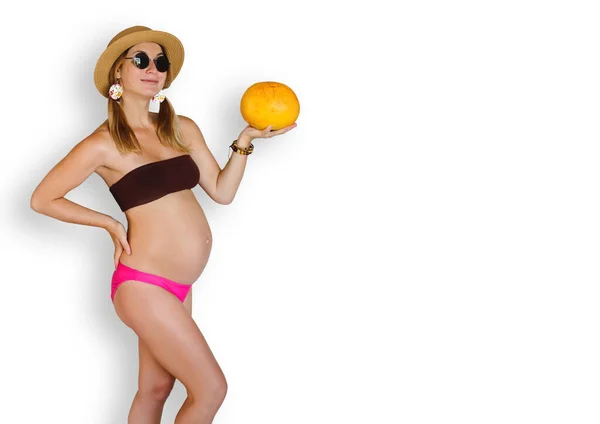 照片拍摄的是一位身披瓜果和帽子的孕妇在演播室里的照片 — 图库照片