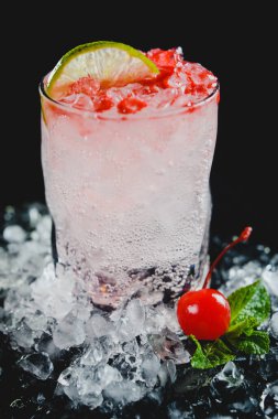 Siyah arka planda buzlu ve meyveli alkollü kokteyl.