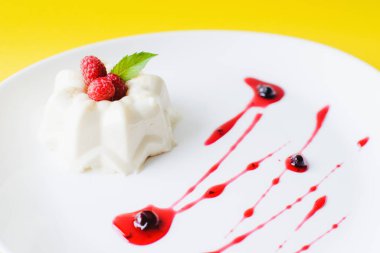 Ahududu, nane ve şuruplu beyaz tabakta jöle kreması.