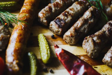 Çeşitli sosisler, pastırma ve baharatlı ızgara et, turşu ve ekmek. Sırp chevapchichi. Mutfak ve restoranda servis. makro