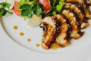 Restoranda masa örtüsüyle kaplı bir masada bir tabak servis edilir. Balık tabağı, deniz tarağı, alet edevat, sos. Makro