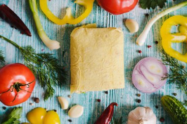 Shawarma, açık sarı lavaşlı, sebzeli ve ahşap ahşap dokulu bir masada et. Kestik. Biber, soğan, sarımsak, maydanoz..