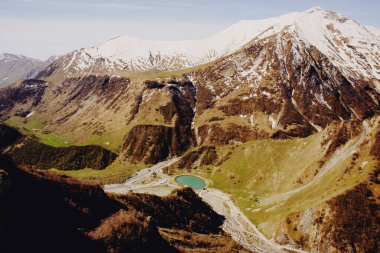 Mavi gökyüzü olan güzel bir dağ manzarası. Stepantsminda Georgia 'da Kazbek Dağı' nın karla kaplı zirvesi