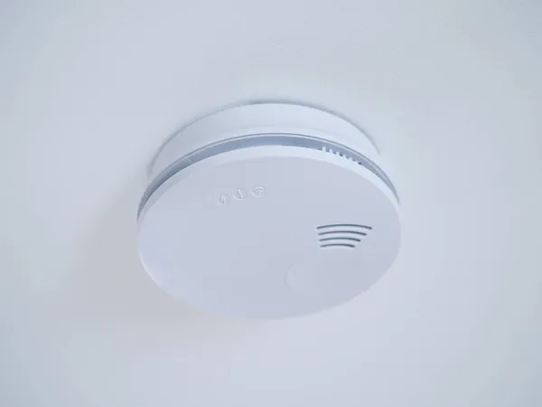Kulatý bílý požární senzor nebo detektor kouře na stropě — Stock fotografie