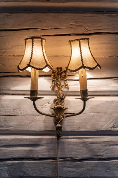 Lâmpada dupla de bronze vintage velha na parede de madeira branca — Fotografia de Stock