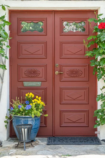 Porta de entrada de madeira vermelha velha com flores e decorações — Fotografia de Stock