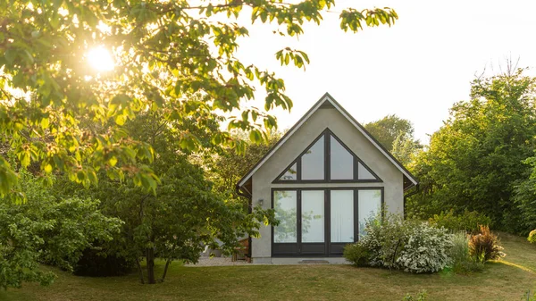 Obrázek krásné zahrady s jabloněmi, květy a skandinávský styl letní dům Stock Snímky