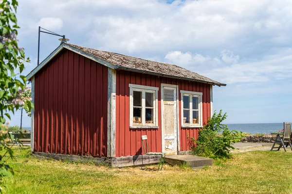 Edificios escandinavos de madera roja sobre el fiordo. Techos negros y verdes. La costa del centro de Suecia. — Foto de Stock