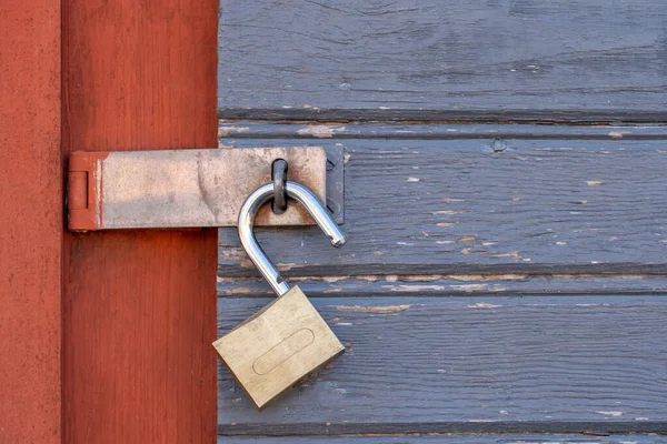 Velho cadeado desbloqueado em uma porta de madeira — Fotografia de Stock