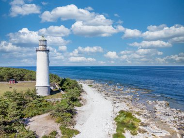 Image of Aerial view of white lighthouse at the beach with sea and clouds