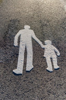 Image of Asphalt road with white pedestrians sign painted on it, warning pavement sign