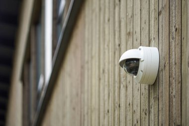 Image of Round shaped weathersealed Security camera on the wooden wall