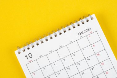 Ekim ayında, Takvim masası 2022 düzenleyici için sarı arkaplan üzerinde planlama ve hatırlatma.