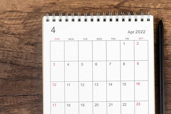 トップビューカレンダーデスク2022 4月のカレンダー計画と木製のテーブルの背景に鉛筆 事業計画選任会議の概念 — ストック写真
