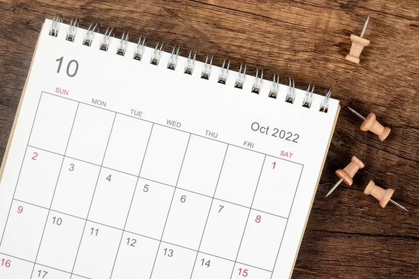 トップ表示カレンダーデスク2022年10月 木製のテーブルの背景にプッシュピンで計画と締め切りの概念 事業計画選任会議の概念 — ストック写真