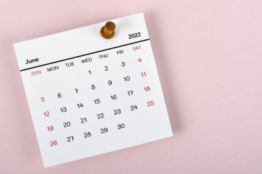 Takvim masası 2022 Haziran 'da, takvim tarihine bir basım iğnesiyle planlama ve teslim tarihi kavramı.
