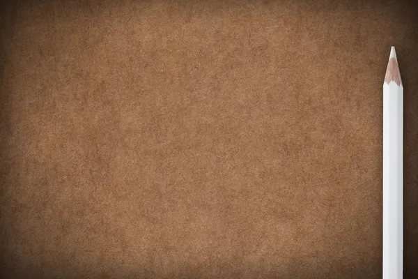 茶色の紙の背景に白いクレヨン — ストック写真