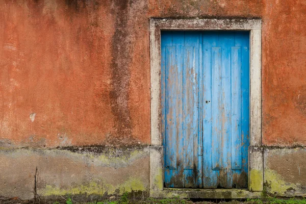 Przód opuszczonego domu z niebieskimi drzwiami — Zdjęcie stockowe