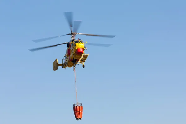 PENELA, PORTUGAL - 28 AOÛT : Hélicoptère lourd de sauvetage incendie, avec seau d'eau, se préparant à ramasser l'eau pour combattre un incendie à Penela 28 août 2010 à Penela, PORTUGAL — Photo
