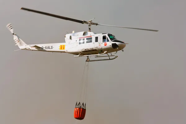 ПОМБАЛ, ПОРТУГАЛЬ - 1 ОКТЯБРЯ: Пожарно-спасательный тяжелый вертолет, с ведром для воды, собирается стрелять в Помбале 1 октября 2011 года в Помбале, ПОРТУГАЛЬ — стоковое фото