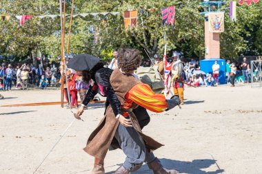 ALCALA DE HENARES, MADRID, SPAIN - 12 Ekim 2021: İki adam 16. yüzyılda bir ortaçağ festivalinin kutlaması sırasında halka kılıç dövüşünün nasıl bir şey olduğunu gösteriyor