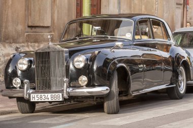 ALCALA DE HENARES, MADRID, SPAIN - 11 Ekim 2018: 1957 'den kalma klasik Rolls-Royce gümüş bulutu kilisenin kapısında yeni evlileri bekliyor. Düğünler için en çok kiralanan klasiklerden biri