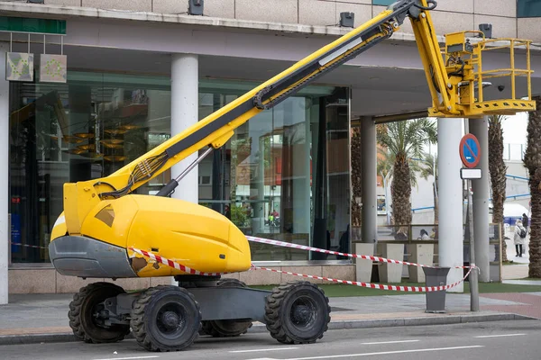 Closeup Horizontal View Articulated Boom Lift Yellow Color Parked Street — 스톡 사진