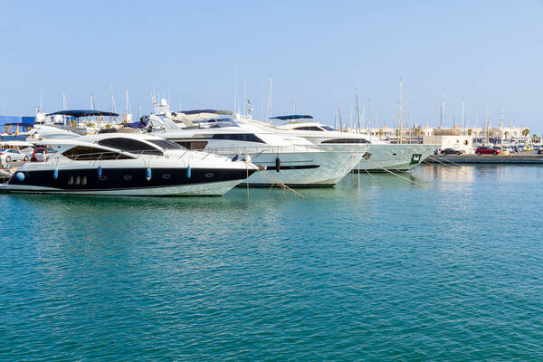 horizontal view of the marina with three yachts docked in the foreground
