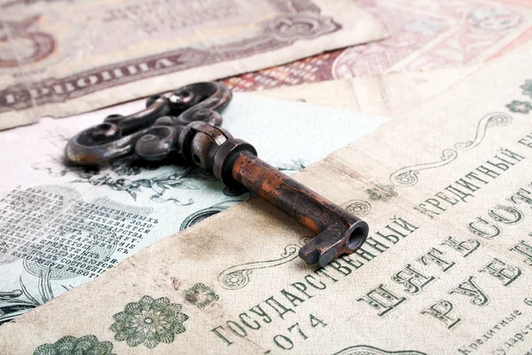 Financiën concept, oude geld en sleutel — Stockfoto