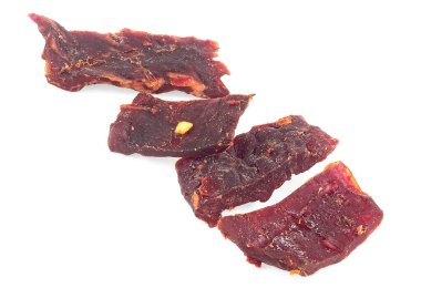 Beyaz arka planda izole edilmiş kurutulmuş et parçaları. Baharatlı kurutulmuş et..