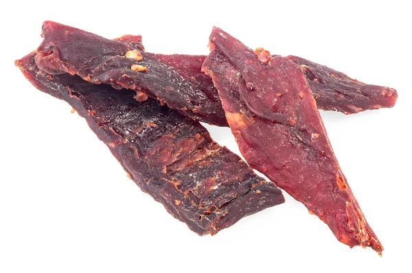 Spiced beef jerky pieces isolated on a white background. Portion of sliced and dried meat.