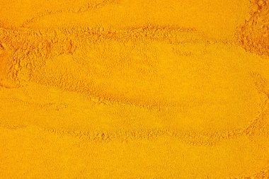 Curcuma powder spice as background, top view. Ground turmeric.