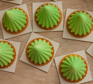 Bisküvinin üzerine yeşil koni kekleri.