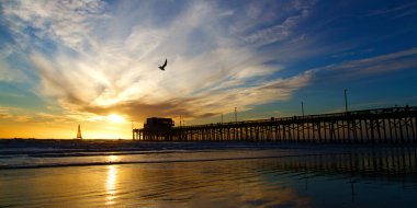 Newport Beach California Pier at Sunset in the Golden Silhouette clipart