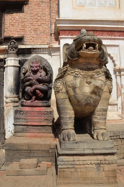 Nepál, Bhaktapuru, durbar náměstí. hanuman božstvo a kamenného lva nedaleko vchodu do královského paláce. — Stock fotografie