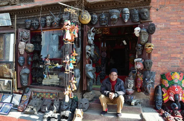 Nepal, o vendedor senta-se na entrada da loja de presentes em Kathmandu — Fotografia de Stock