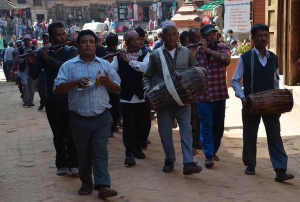 Bhaktapur, Nepal, festività in onore del nuovo anno nepalese. Gli uomini vanno per strada e suonano strumenti musicali . — Foto Stock