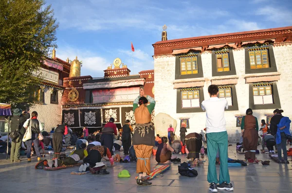 Tibet, Lhasa, Buddhists make prostration (pray) before the first Buddhist temple in Tibet, the Jokhang — Stock Photo, Image