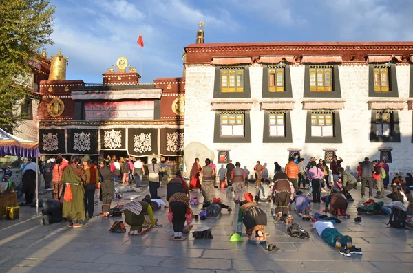 Tibet, Lhasa, Buddhists make prostration (pray) before the first Buddhist temple in Tibet, the Jokhang — Stock Photo, Image