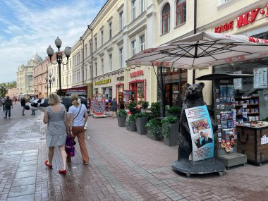 Moskova, Rusya, 20 Ağustos 2021. İnsanlar yazın Moskova 'da Arbat caddesinde hediyelik eşya dükkanının yanında yürürler.