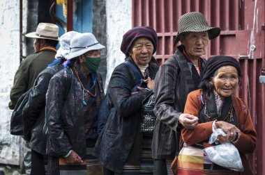 LHASA, TIBET, CHINA - AUGUST, 17 2018: Unidentified Tibetan pilgrims with with typical clothing near the old Jokhang Temple in Lhasa, Tibet clipart