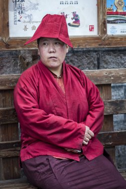 LHASA, Tibet, ÇİN - 17 Ağustos 2018: Geleneksel giysiler içindeki tanımlanamayan Tibetli adam Jokhang Tapınağı yakınlarındaki bir bankta oturuyor 