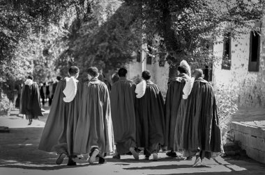 LHASA, Tibet, Çin - 17 Ağustos 2018: Sera manastırının girişindeki sarı şapkalı Tibetli Budist keşişler. Tibet 'in Gelug üniversite manastırlarından biri olan Lhasa Tibet